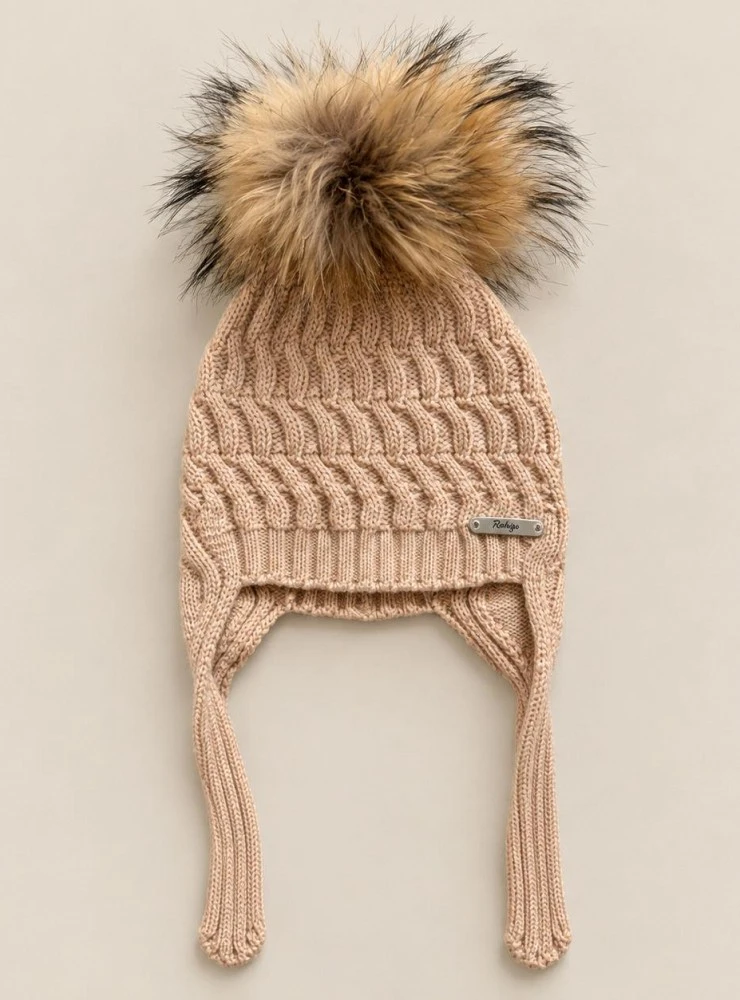 Children's cable-knit hat with earflaps and a natural fur pom-pom.