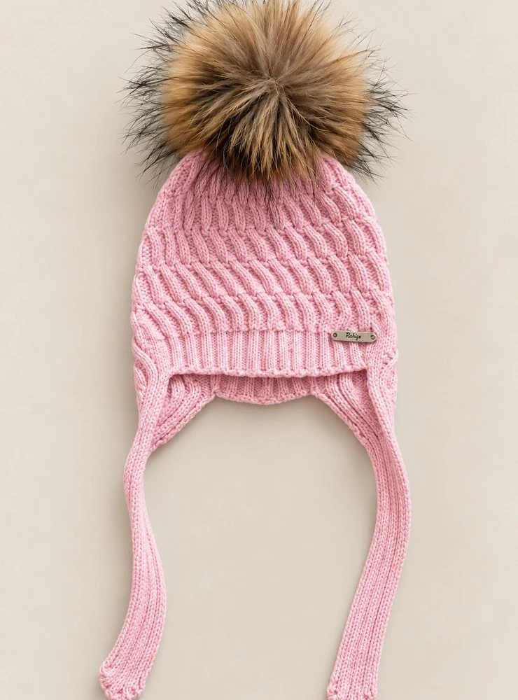 Children's cable-knit hat with earflaps and a natural fur pom-pom.