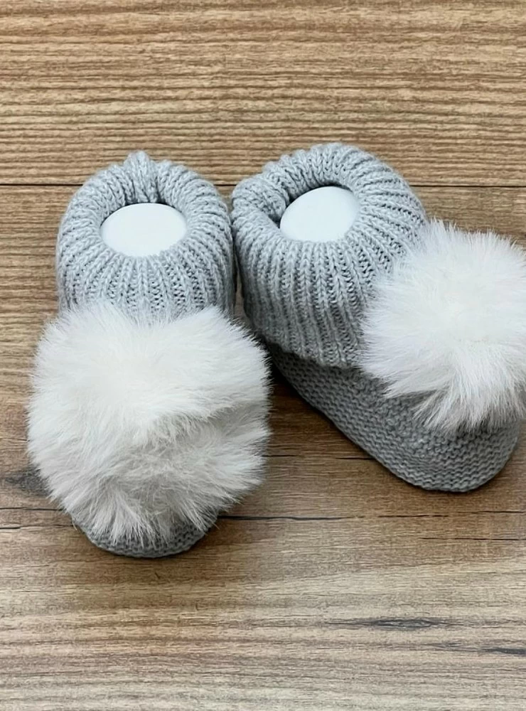 Chubby knit bootees with a fur pompom. Adriatic Collection
