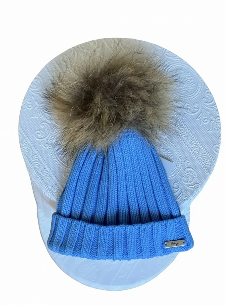 Ribbed hat in various colors. She wears a hair pompom.