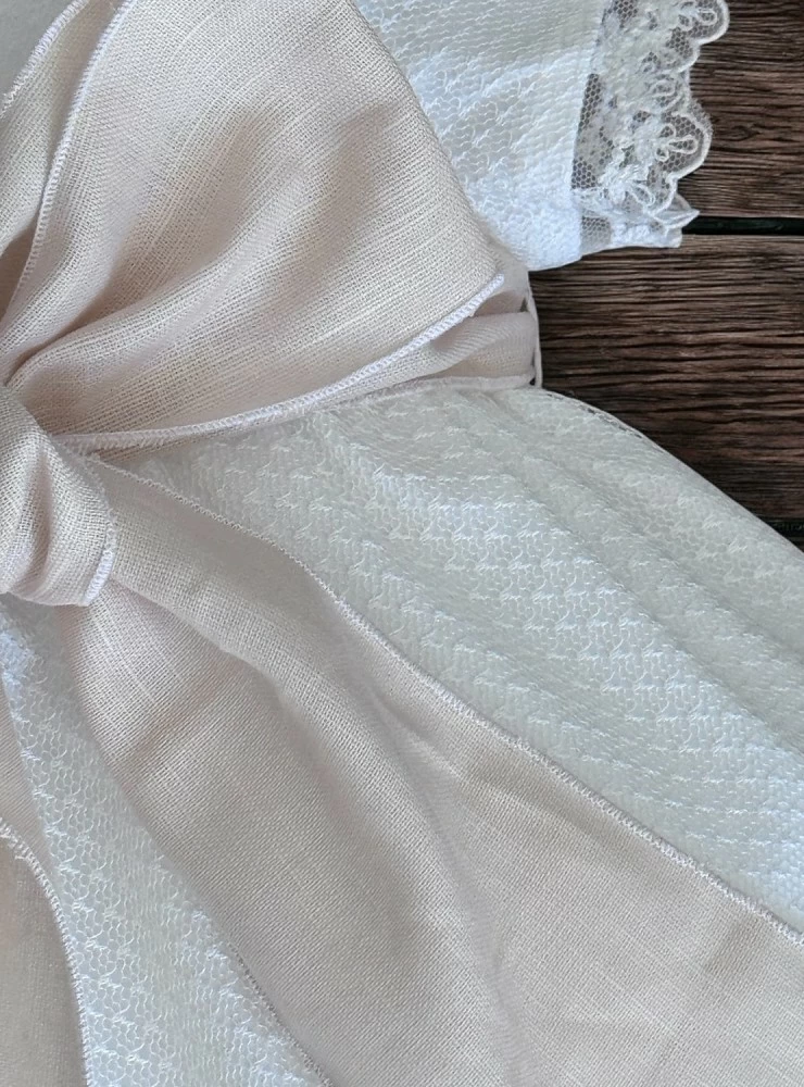 Sand-colored romper and bonnet with bow. Nido Collection.