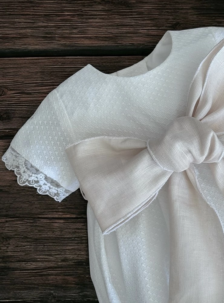 Sand-colored romper and bonnet with bow. Nido Collection.